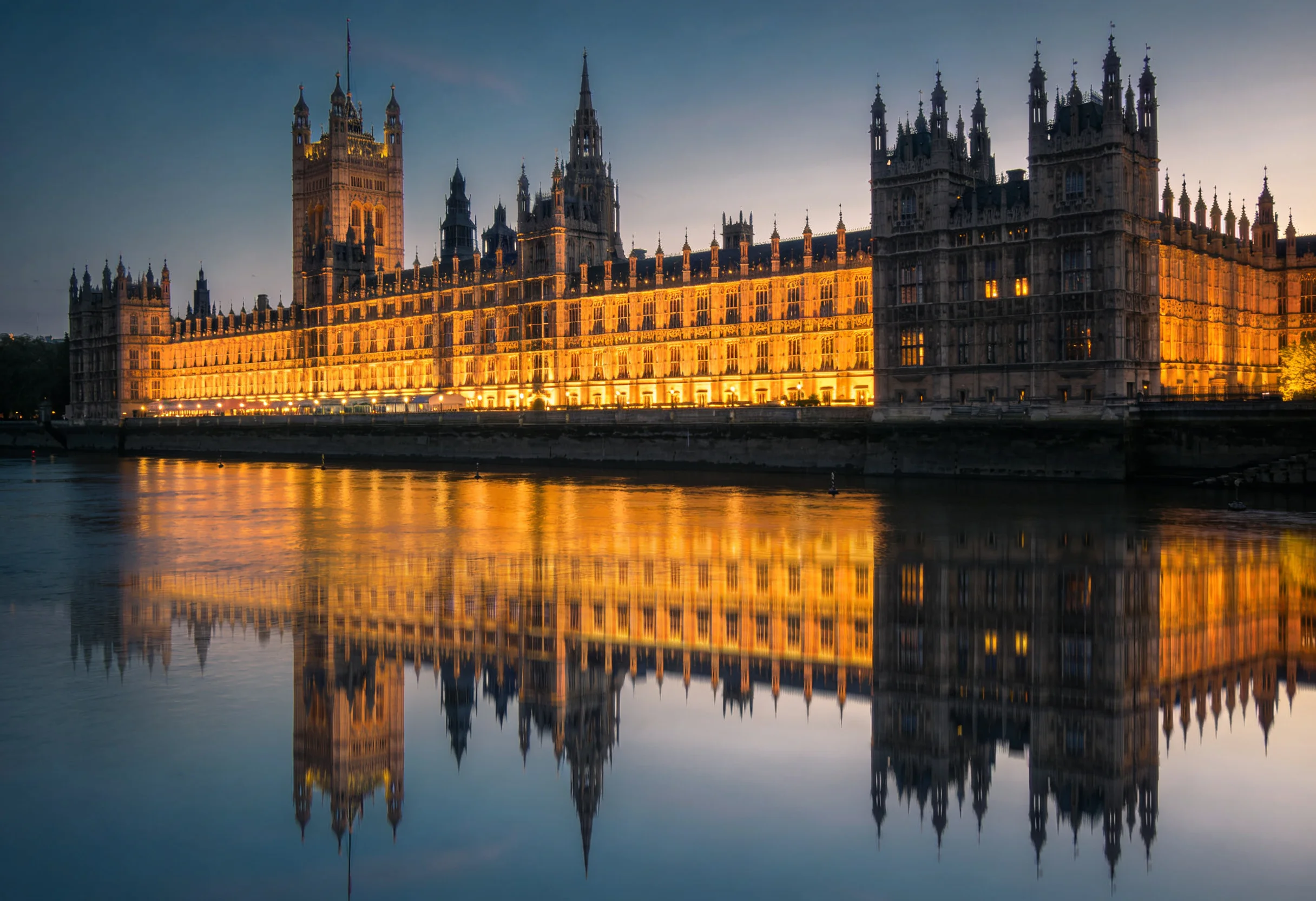 UK Parliament building at dusk with the Thames in the foreground representing British gambling regulation