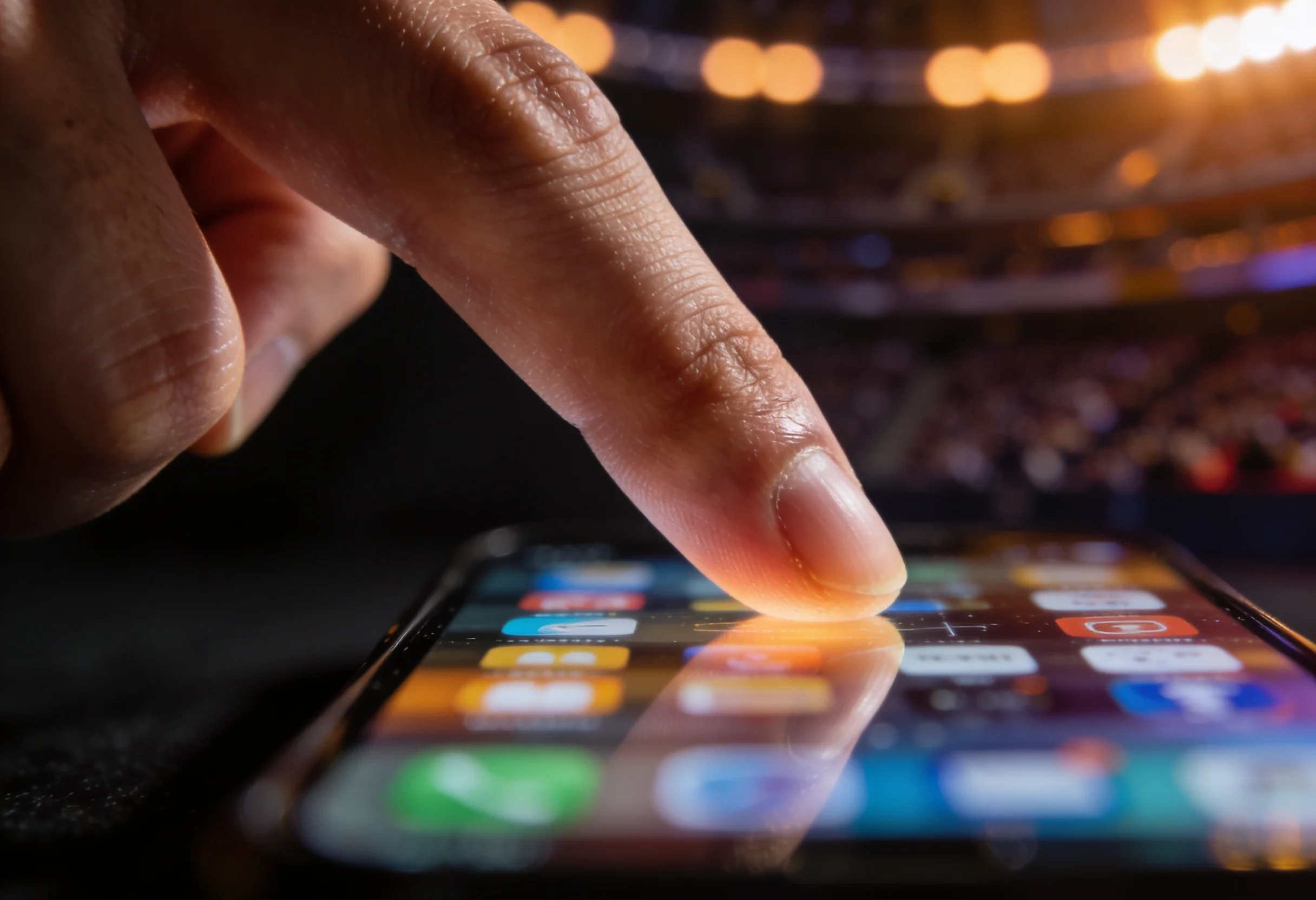 A finger hovering over a smartphone screen button during a live UFC event